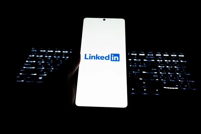 Close-up of LinkedIn logo on smartphone with backlit keyboard in dark room. Hvilke felter bør en virksomhedsprofil indeholde?